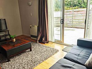 sala de estar con sofá y puerta corredera de cristal en Newlands Court Motel, en Wellington