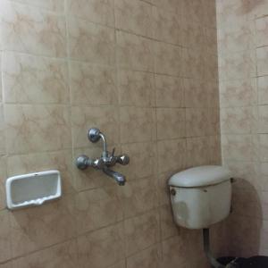 a bathroom with a toilet in a tiled wall at Shanti Guest Guest House Varanasi by GRG in Varanasi