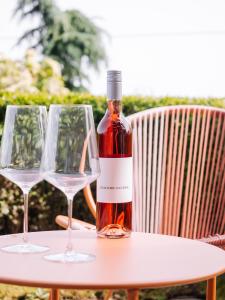 a bottle of wine sitting on a table with two glasses at SCHILCHERLANDLEBEN - Langegg in Greisdorf