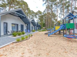 a playground with a slide in front of a house at Comfortable holiday cottages, Jaros awiec in Jarosławiec