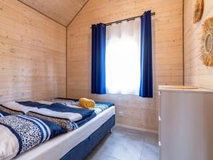 a room with a bed in a wooden room with a window at Comfortable holiday cottages, Jaros awiec in Jarosławiec