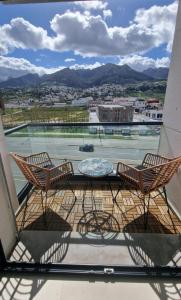 een balkon met 2 stoelen en een glazen tafel bij Luxe Appartement in Tetouan in Tetouan