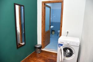 a washing machine in a bathroom with a mirror at Woodland City Center in Berat
