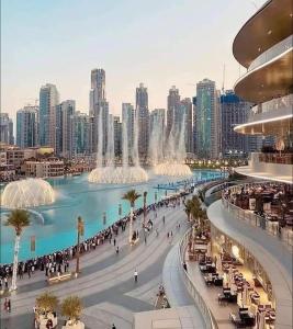 a view of a city with tall buildings and a fountain at Stanley Hostel in Dubai