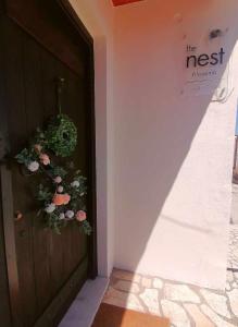 een deur met bloemen aan de zijkant van een gebouw bij The Nest Filoxenia in Kato Trikala Korinthias