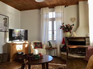 a living room with a tv and a table and a couch at The Nest Filoxenia in Kato Trikala Korinthias
