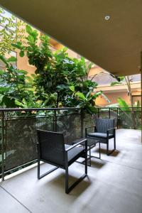 2 sedie e un tavolo sul balcone con alberi di 2BR Hollywood Modern Luxury Condo a Los Angeles