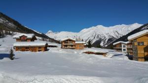 a group of buildings in the snow with mountains at Chalet Breithorn- Perfect for Holiday with Amazing View! in Obergesteln