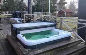 a hot tub sitting on top of a deck at 4 Bedroom Stunning Home In Ljusterö in Norra Ljustero +4 photos