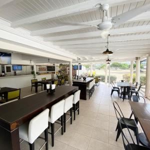 une salle à manger avec des tables, des chaises et une table dans l'établissement 12 Foursquare Rockley Golf & Country Club, à Bridgetown
