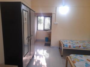 Habitación con 2 camas y pasillo con ventana en Swami Sahvas Homestay, en Kudāl