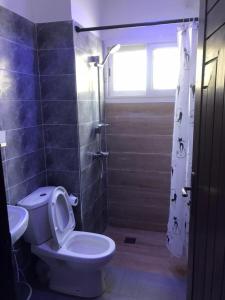 a bathroom with a toilet and a shower with a window at Cozy Appartement Dakar in Dakar +20 photos