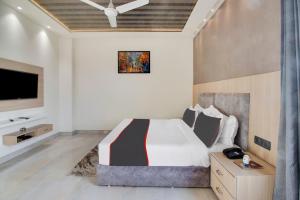 1 dormitorio con 1 cama grande y TV en Collection O Amber Heights near Satellite Bus Stand, en Bareilly