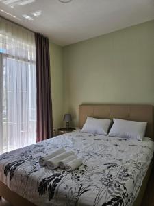 um quarto com uma cama grande com duas toalhas em Apartments LOTUS em Gevgelija