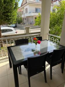 une table noire avec un vase de fleurs sur un balcon dans l'établissement Şehir Merkezinde kiralık Daire, à Fethiye