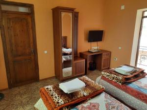 Habitación con 2 camas, tocador y espejo. en Inn Sogdiana, en Panjakent