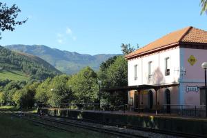 ヌエバ・デ・リャネスにあるAcogedor bajo con terraza y vistasの線路横の建物のある鉄道駅