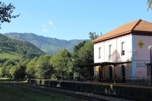 a train station with a building next to the tracks at Acogedor bajo con terraza y vistas in Nueva de Llanes