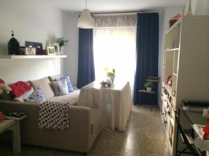 a living room with a couch and a window at URBION HOME in Seville