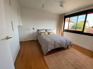 ein Schlafzimmer mit einem Bett und einem großen Fenster in der Unterkunft JO maison spacieuse 10 mn Paris in Villejuif