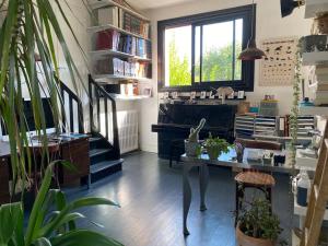 ein Wohnzimmer mit einem Tisch und einem Klavier in der Unterkunft JO maison spacieuse 10 mn Paris in Villejuif