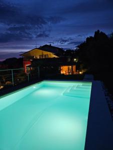 uma piscina iluminada à noite em B&B Corte Frisonai em Bardolino