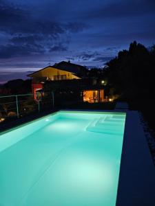 una piscina iluminada por la noche en B&B Corte Frisonai, en Bardolino