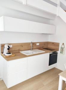 eine Küche mit weißen Schränken und einem Waschbecken in der Unterkunft Maison proche centre, gare, aux Sables d'olonne in Les Sables-dʼOlonne