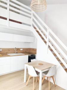 a kitchen with white cabinets and a table and chairs at Maison proche centre, gare, aux Sables d'olonne in Les Sables-dʼOlonne