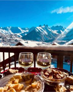 un tavolo con due bicchieri di vino e cibo di Les sybelles a La Chal