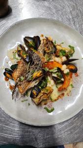 a plate of food with mussels and vegetables on it at Vilajoun in Joucas