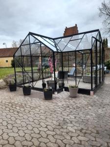 a greenhouse with potted plants in it at Villa Wolte Bed and Breakfast in Ringsted