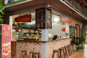 a restaurant with stools in front of a brick wall at Wafami Hostel Ninh Binh in Ninh Binh +48 photos