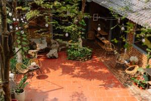 patio z krzesłami i stołem oraz roślinami w obiekcie Wafami Hostel Ninh Binh w mieście Ninh Binh