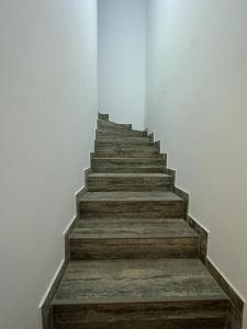 eine Treppe in einem weißen Zimmer mit Holztreppe in der Unterkunft Casa duplex in Alba Iulia