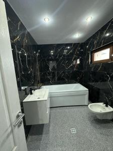 ein Badezimmer mit einer Badewanne, einem Waschbecken und einem WC in der Unterkunft Casa duplex in Alba Iulia