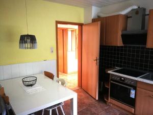 a kitchen with a table and a kitchen with yellow walls at Ferienwohnung mit Balkon 1.OG in Neustadt bei Coburg