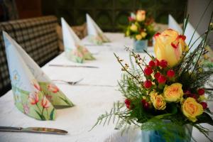 une longue table avec des fleurs dans des vases dans l'établissement Gasthof Zur Seku, à Neunkirchen am Brand