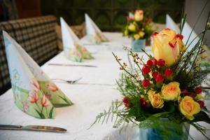Una mesa larga con flores en jarrones. en Gasthof Zur Seku, en Neunkirchen am Brand