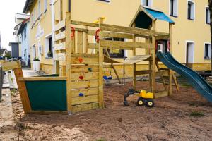 a wooden play structure with a slide and a playground at Gasthof Zur Seku in Neunkirchen am Brand