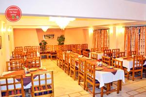 une salle à manger avec des tables et des chaises en bois dans l'établissement Hotel Radha Continental Nainital Near Mall Road - Hygiene & Spacious Room - Prime Location - Best Selling, à Nainital