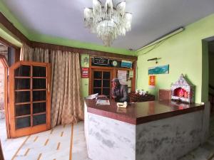 une personne assise au comptoir d'un restaurant dans l'établissement Hotel Radha Continental Nainital Near Mall Road - Hygiene & Spacious Room - Prime Location - Best Selling, à Nainital
