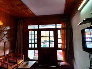 - un salon avec une grande fenêtre et une télévision dans l'établissement Hotel Radha Continental Nainital Near Mall Road - Hygiene & Spacious Room - Prime Location - Best Selling, à Nainital