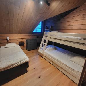Idre Mountain Lodge في إدري: سريرين بطابقين في غرفة مع جدران خشبية