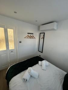 een slaapkamer met 2 handdoeken op een bed bij The Little Lodge in Horley