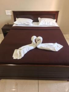 a bed with two swans made out of towels at Hotel Mint Leaf in Kāgal