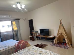 een slaapkamer met een bed en een televisie en een tent bij Dou Dou Long Homestay in Donggang