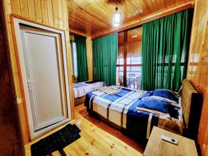 a bedroom with two beds and a large window at GUEST HOUSE NONA in Chakvi