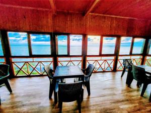 - une table et des chaises dans une chambre avec vue sur l'océan dans l'établissement GUEST HOUSE NONA, à Chakvi