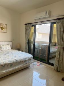 een slaapkamer met een bed en een glazen schuifdeur bij Dou Dou Long Homestay in Donggang